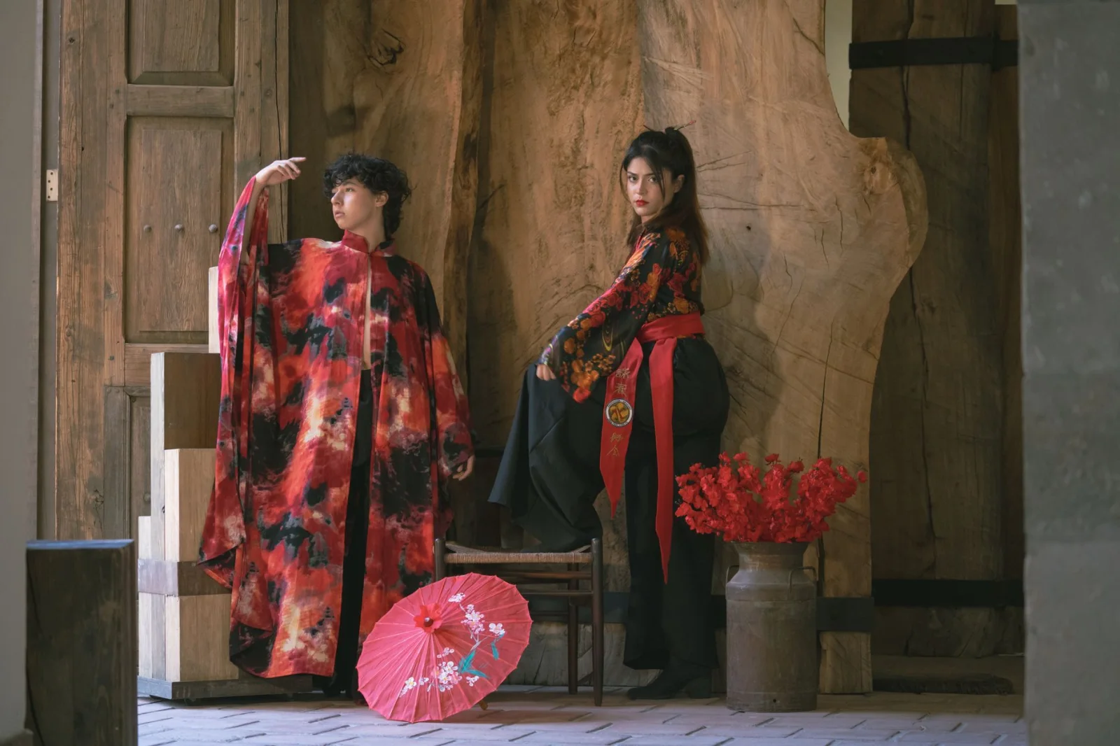 Two models in vibrant kimonos posed indoors with traditional decor and red accents.