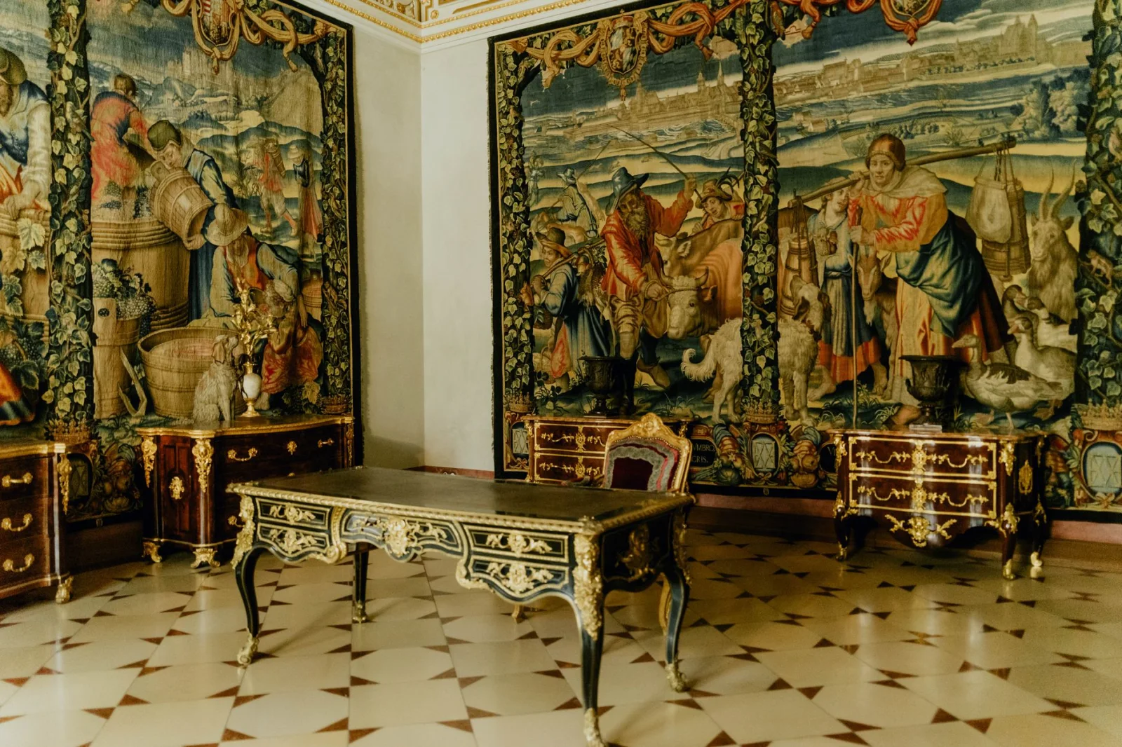 Luxuriöser Raum mit kunstvollen Wandteppichen, antiken Möbeln und detaillierten Goldakzenten, die historische Eleganz einfangen.