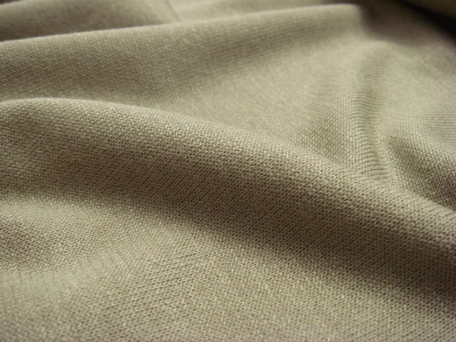 Tissu interlock jersey en gros plan, montrant la texture et les mailles caractéristiques du jersey.